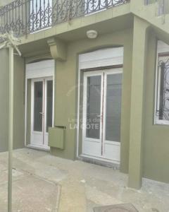 een huis met 2 deuren en een balkon bij Maison "Louisette" in Le Touquet-Paris-Plage