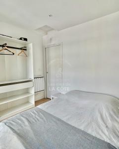 een witte slaapkamer met een bed en een kast bij Maison "Louisette" in Le Touquet-Paris-Plage