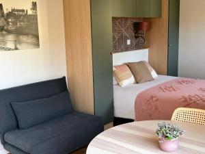 a room with a bed and a couch and a table at Les logis du canal in Betton