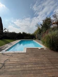 een zwembad in een tuin met een houten terras bij Mas de charme provencal in Cavaillon +17 foto's