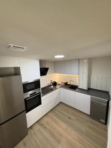 a large kitchen with white cabinets and black appliances at Casa Dolce Casa in Valencia
