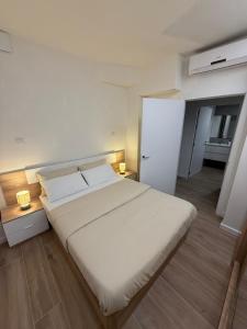 a bedroom with a large white bed with two lamps at Casa Dolce Casa in Valencia +12 photos