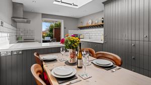 una sala da pranzo con tavolo e sedie e una cucina di Horsefair Cottage a Malmesbury