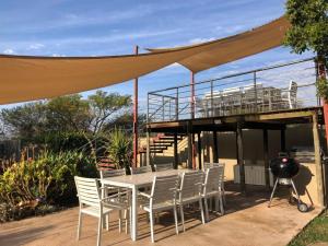 un tavolo e sedie sotto una tettoia con una griglia di 46 Welgevonden in Dinokeng a Dinokeng Game Reserve