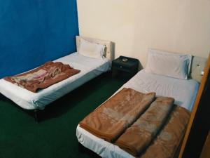 a room with two beds and a couch in it at Grand Arham Hotel in Dargai
