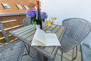 a table with a bottle of wine and a book at Ferienwohnung Strandkiste in Norddeich
