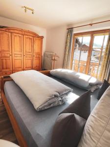 ein Schlafzimmer mit zwei Betten und einem großen Fenster in der Unterkunft Ferienwohnungen Kaiser Franz in Krün