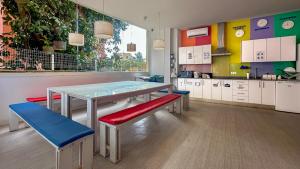 a kitchen with a table and two benches and a table and cabinets at Palma Port Hostel - Albergue Juvenil in Palma de Mallorca