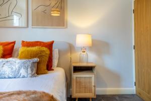 Un dormitorio con una cama y una lámpara en una mesita de noche. en Little Domus - With Hot Tub, en York