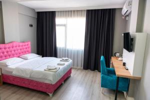 a bedroom with a pink bed and a desk and a television at Rio's Hotel AİRPORT in Istanbul +20 photos