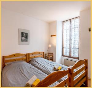 a bedroom with a wooden bed and a window at Le Panorama d'Autrefois I T3 I Talloires in Talloires