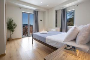 a bedroom with a bed and a large window at Villa Margarita in Pinakokhórion