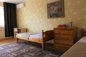 a small bedroom with a bed and a dresser at Апартаменти Амфора in Pomorie