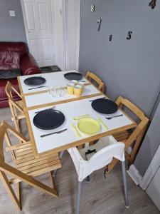a table with chairs and a table with plates on it at Canny Hyem in Birtley