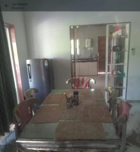 a dining room table with chairs and a refrigerator at Aranya Bliss in Gandhinagar