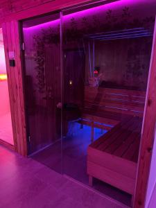 a glass shower in a room with purple lights at Wellness Spa Hotel Zeleni Raj in Banja Luka