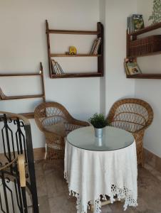 a table with wicker chairs and a table with a plant on it at Casa El Valle Verde Granada in Lecrin