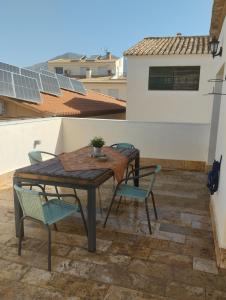 a patio with a table and chairs on a roof at Casa El Valle Verde Granada in Lecrin +8 photos