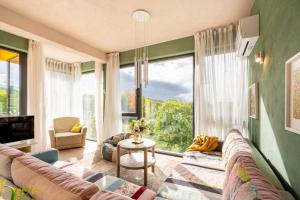 a living room with a couch and a large window at Boutique Hotel Casa Art in Oreshak