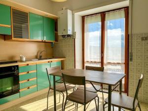a kitchen with green cabinets and a wooden table and chairs at Residenza Labanca in Campobasso