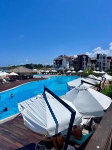 a group of umbrellas sitting next to a swimming pool at Oasis Resort Apartments in Lozenets