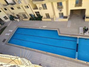 a blue swimming pool in front of a building at كمبوند سكاي 2 in Hurghada