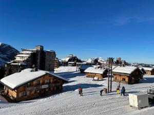 a group of people standing in the snow near buildings at Une escale face au lac Léman in Marin