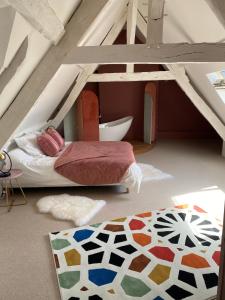 a attic bedroom with a bed and a rug at La Maitrise à BAYEUX in Bayeux