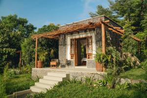 a small house in a garden with a porch at Mateves boutique lodge in Arusha