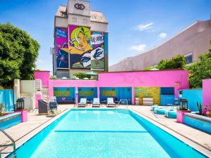 a pool on the side of a building with a clock tower at Hotel Sofitel Los Angeles at Beverly Hills in Los Angeles