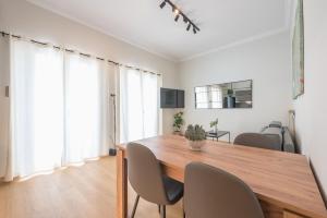 Un comedor con mesa y sillas de madera. en Platon At Philopappou By Greece Apartments, en Atenas