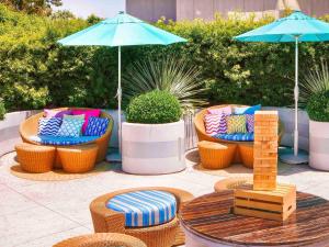 a group of chairs and a table with an umbrella at Hotel Sofitel Los Angeles at Beverly Hills in Los Angeles