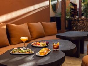 a table with two plates of food and a drink at Hotel Sofitel Los Angeles at Beverly Hills in Los Angeles
