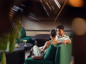 a man and a woman sitting in chairs in a room at Hotel Sofitel Los Angeles at Beverly Hills in Los Angeles