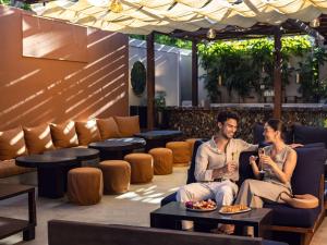 a man and a woman sitting on a couch at Hotel Sofitel Los Angeles at Beverly Hills in Los Angeles