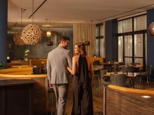 a man and a woman standing in a restaurant at Hotel Sofitel Los Angeles at Beverly Hills in Los Angeles
