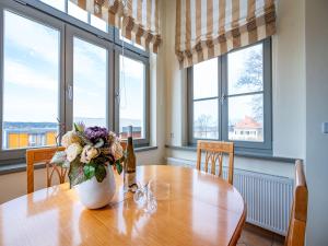 ein Esstisch mit einer Vase mit Blumen darauf in der Unterkunft Villa San Marino, App 5 in Heringsdorf + 9 Fotos
