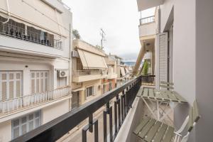 Un balcón de un edificio con bancos en él. en Platon At Philopappou By Greece Apartments, en Atenas