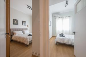 Un dormitorio con dos camas y una ventana. en Platon At Philopappou By Greece Apartments, en Atenas