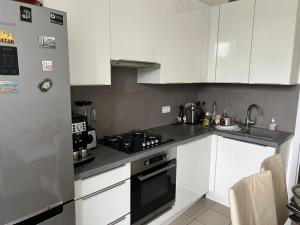 una cucina con mobili bianchi e un forno a piano cottura di Poletti a Wemmel