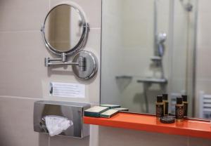 a bathroom with a mirror and a shelf with cosmetics at Hôtel CASABELLA Cannes Mouans Sartoux in Mouans-Sartoux +85 photos