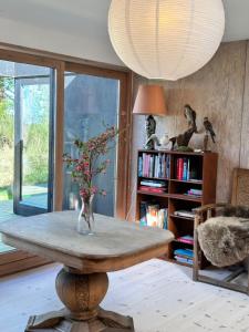 a room with a table with a vase with flowers on it at Seaside holiday home in Grenå