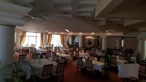 a banquet hall with white tables and chairs at Hotel President in Arad