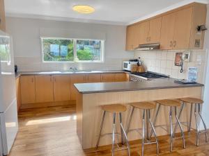 a kitchen with wooden cabinets and a counter with stools at Huski Ski Club in Mount Buller