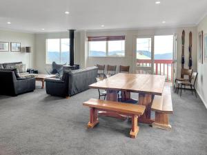 a living room with a wooden table and chairs at Huski Ski Club in Mount Buller