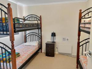 a bedroom with two bunk beds and a night stand at Huski Ski Club in Mount Buller