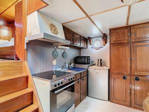 a kitchen with wooden cabinets and a stove top oven at La Marquise "dormez dans une péniche" in Melun
