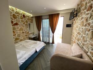 una camera da letto con un letto e un muro di pietra di Lila view a Qeparo