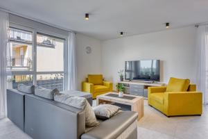 sala de estar con sofá, 2 sillas y TV en Monika&Jozsef, en Poreč