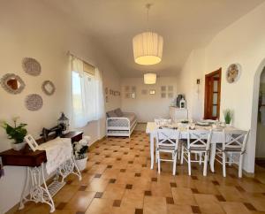 a dining room with a white table and chairs at Le Trame di Ka.Sa in Porto Ottiolu